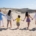 Familia caminando de la mano por la playa durante las vacaciones de verano